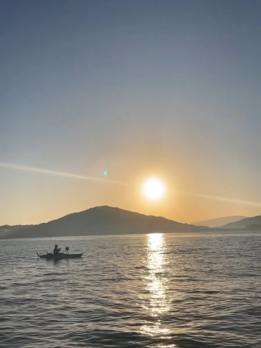 夕日の海に浮かぶ小舟